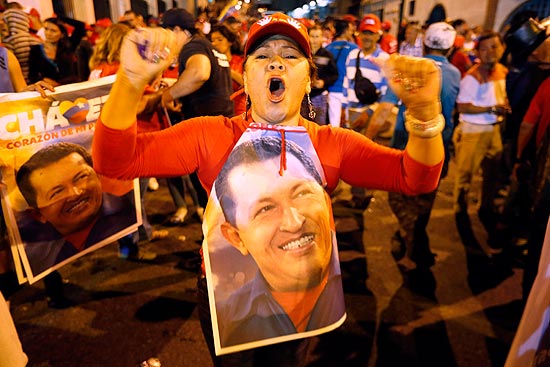 Simpatizante de Hugo Chvez festeja diante do Palcio Miraflores, em Caracas,  espera de resultados de eleio