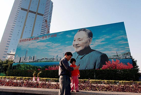 Chineses passam por cartaz de Deng Xiaoping, que iniciou reformas econmicas em 1978