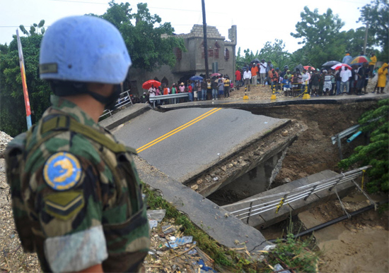 Militar observa ponte destruída durante a passagem do furacão Sandy pelo Haiti; ao menos nove pessoas morreram 