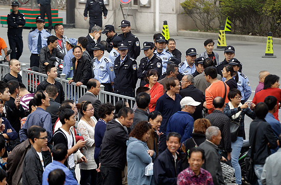 Policiais monitoram movimento de cidados em frente  Prefeitura de Ningbo, na China