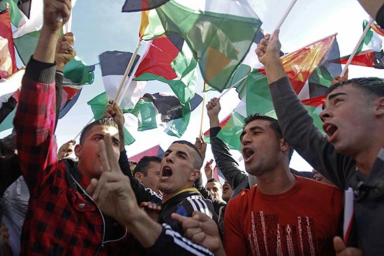 Palestinos comemoram com bandeiras a volta de Mahmoud Abbas à Cisjordânia e a recente vitória na ONU