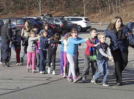 Policiais de Connecticut, nos EUA, levam crianas em fila aps tiroteio na escola Sandy Hook, em dezembro de 2012