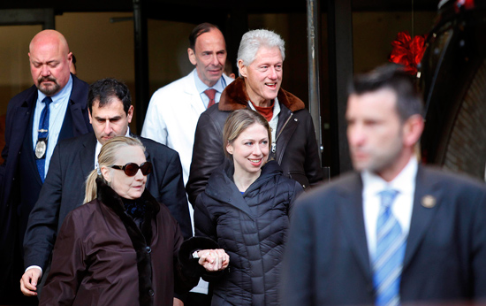 Hillary (abaixo,  esq.) deixa hospital em Nova York ao lado da filha Chelsea e do marido, Bill Clinton (alto,  dir.)