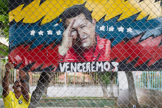 Vestindo a camisa da selao brasileira, venezuelano pendura cartaz de apoio a Hugo Chvez, em Caracas