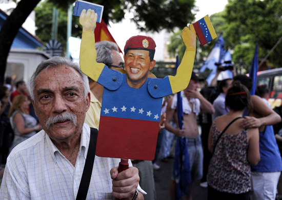 Homem exibe cartaz de Chvez durante ato de apoio ao presidente, na embaixada venezuelana em Buenos Aires