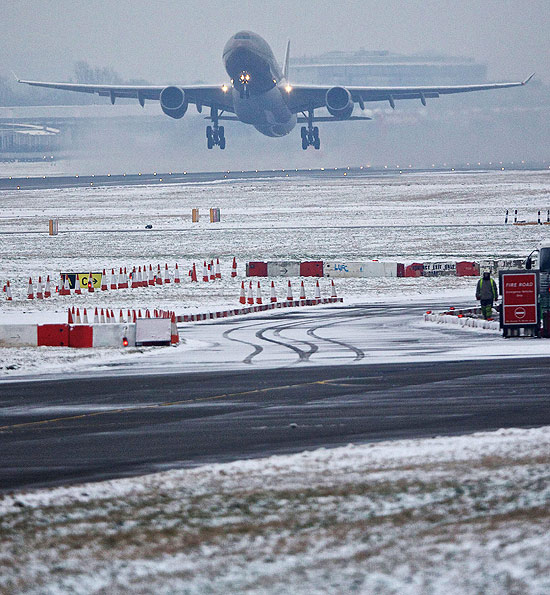 ORG XMIT: JR1006 A passenger plane takes off from the snowy runway at Heathrow airport in west London on January 21, 2013 after the airport announced further flight cancellations due to adverse weather. London's Heathrow Airport warned of further flight cancellations on January 21 which would leave thousands more passengers stranded on the fourth day of delays after heavy snow swept across Britain. AFP PHOTO/ANDREW COWIE