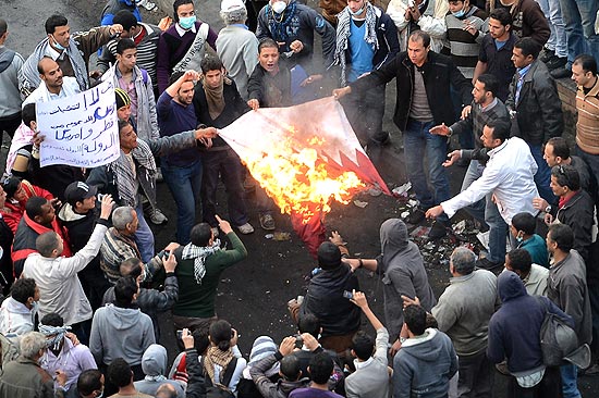 ORG XMIT: KLD611 Egyptian protesters burn the Qatari flag in Cairo's Tahrir Square on January 27, 2013. Clashes killed at least 31 people in Egypt's Port Said as violence raged into the early hours in several cities including the capital following death sentences passed on 21 football fans after a riot. AFP PHOTO / KHALED DESOUKI