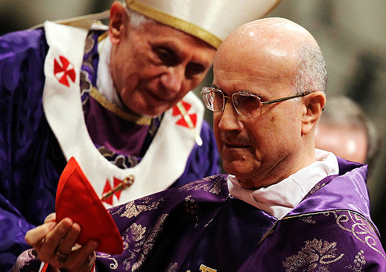 O cardeal Tarcisio Bertone,  direita, durante missa de quarta-feira de Cinzas, no Vaticano; atrs, o papa Bento 16