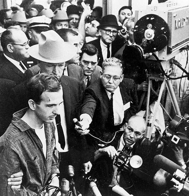 ORG XMIT: 10008441 *** USO FOLHA*** 24 Nov 1963, Dallas, Texas, USA --- A television news conference captures guards and secret service agents escorting Lee Harvey Oswald at the Dallas police headquarters two days after his arrest in conjunction with the assassination of President Kennedy. Oswald was shot by local night club owner Jack Ruby shortly after this photograph was taken. --- Image by � CORBIS ***DIREITOS RESERVADOS. N�O PUBLICAR SEM AUTORIZA��O DO DETENTOR DOS DIREITOS AUTORAIS E DE IMAGEM***