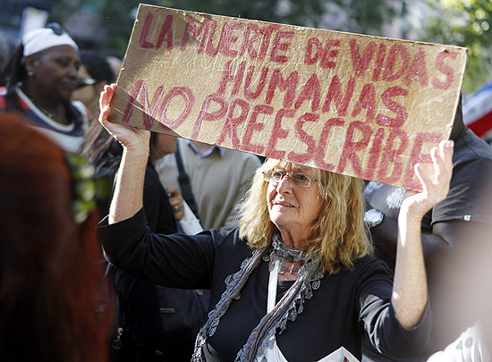 Mulher protesta em Montevidu com cartaz em que se l: "a morte de vidas humanas no prescreve"