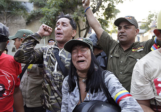 Apoiadores de Hugo Chvez reagem diante da informao da morte do presidente venezuelano, ocorrida na tera (5), em Caracas