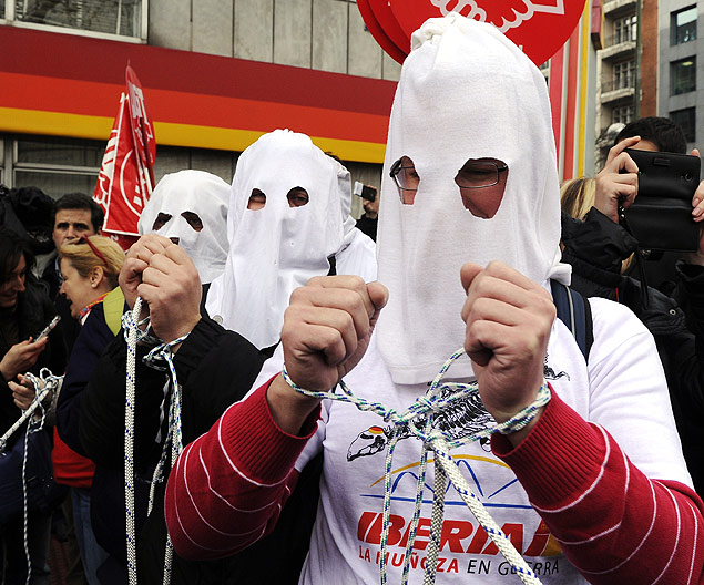 Funcionrios da Iberia usam mscaras e amarram as mos em posio de condenados  morte em protesto na sede da empresa, em Madri