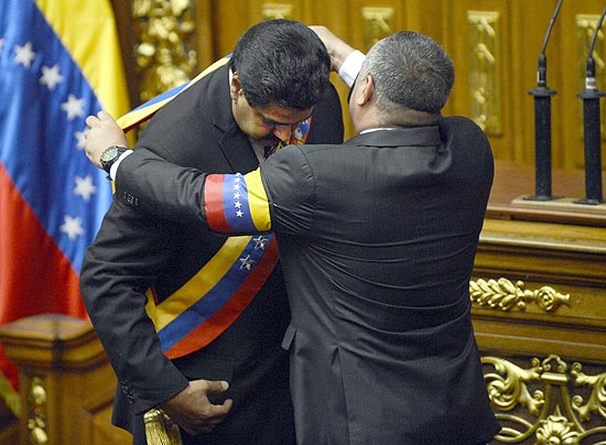 Presidente da Assembleia Nacional da Venezuela, Diosdado Cabello entre a faixa presidencial a Nicolás Maduro, que assume como presidente interino
