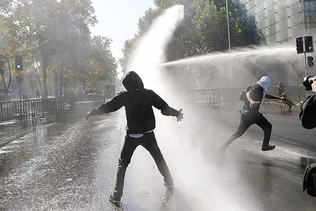 Estudante  atingido por canho d'gua durante manifestao pedindo reforma universitria em Santiago, no Chile