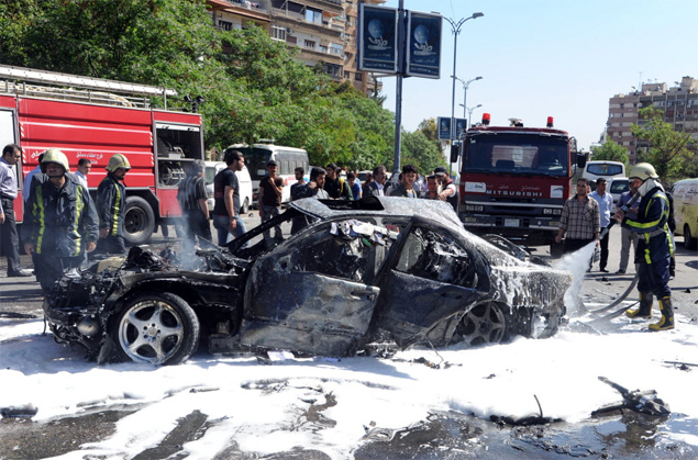 Bombeiros apagam incndio em veculo de comboio do primeiro-ministro srio, alvo de atentado em Damasco 