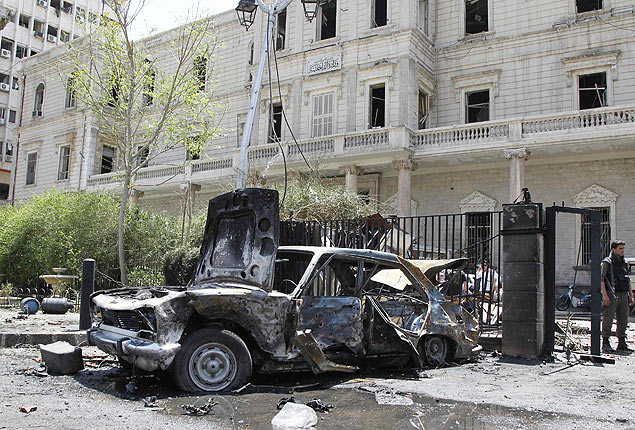 Carro  destrudo ao lado do Ministrio do Interior da Sria aps ataque  praa Marjeh, em Damasco