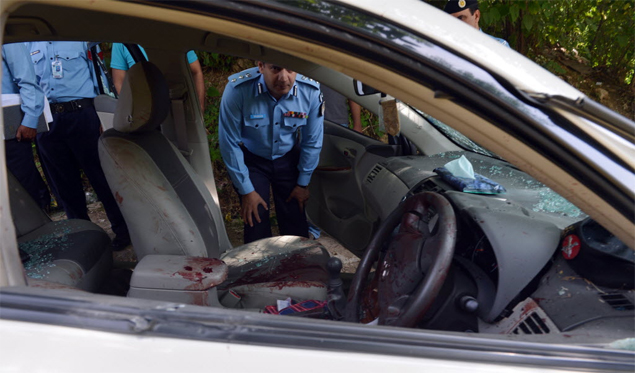 Policial observa interior do carro de promotor que foi assassinado em Islamabad; ele liderava a acusao contra o ex-ditador Pervez Musharraf 