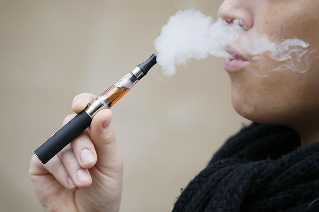 Pessoa fuma cigarro eletrônico, em Paris; equipamento será proibido em locais públicos e para menores de 18