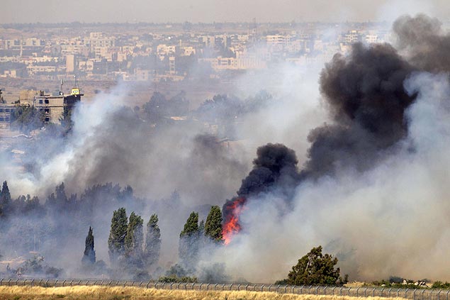 Foto tirada de Israel mostra incndio causado por combates em Quneitra, na Sria, ao lado das colinas de Gol