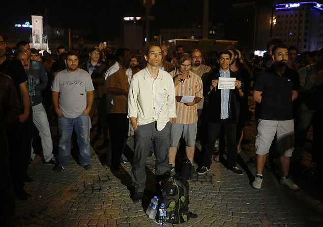 O ator e coregrafo Erdem Gndz, de branco no centro, batizado de o "homem de p", inicia seu protesto silencioso em Istambul, na tera (18)