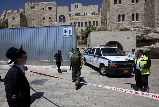 Policiais israelenses isolam local no Muro das Lamentações, em Jerusalém, onde um homem foi morto após gritar 'Alá é grande
