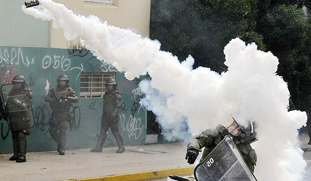 Policial atira bomba de gs lacrimognio durante protesto na cidade de Valparaso, no Chile