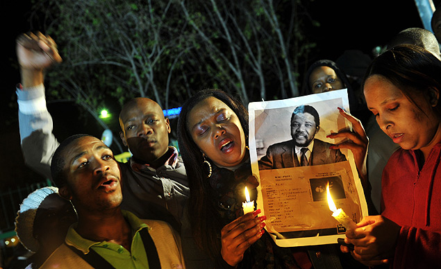 Simpatizantes de Mandela seguram seu retrato e fazem viglia em frente ao hospital onde ele est internado, em Pretria 