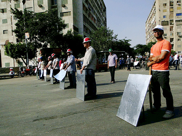 Homens usam placas de metal em barricada contra manifestantes contrrios ao governo 
