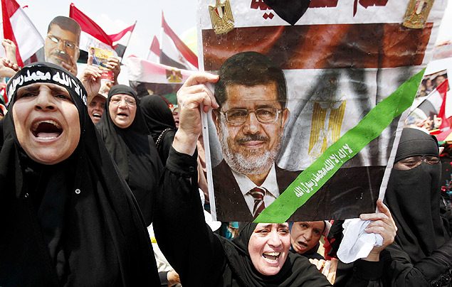 Mulher islamitas com pster de Mursi pede a volta do presidente deposto, no Cairo