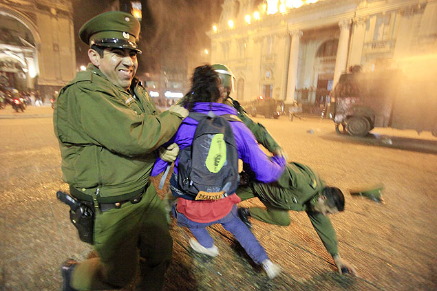 Policiais tentam segurar manifestante na Praa de Armas de Santiago, no Chile, aps invaso  Catedral Metropolitana
