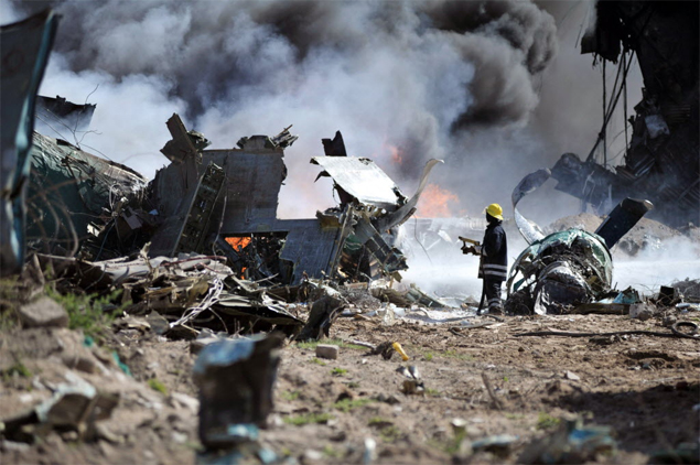 Bombeiro tenta apagar incndio aps queda de avio militar em aeroporto na Etipia; ao menos 4 pessoas morreram