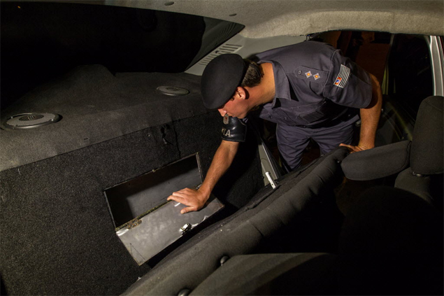 PM observa compartimento secreto em banco traseiro de veículo onde estavam escondidos 15 kg de pasta base de cocaína