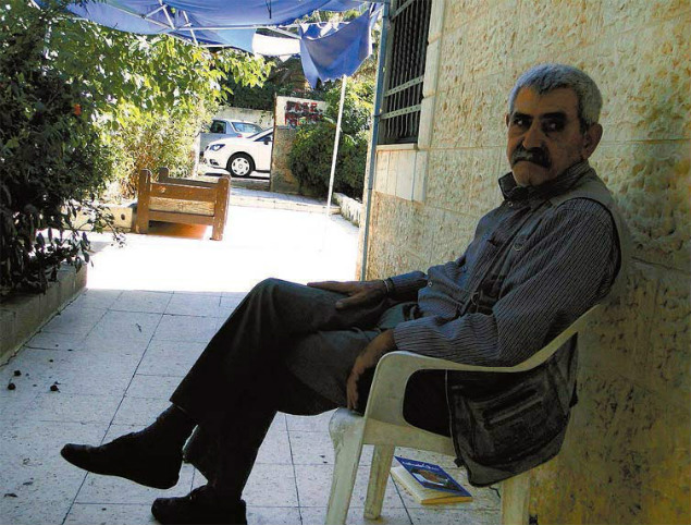 Nabil al-Kurd em sua casa em Sheikh Jarrah; ao fundo, o anexo habitado por israelenses