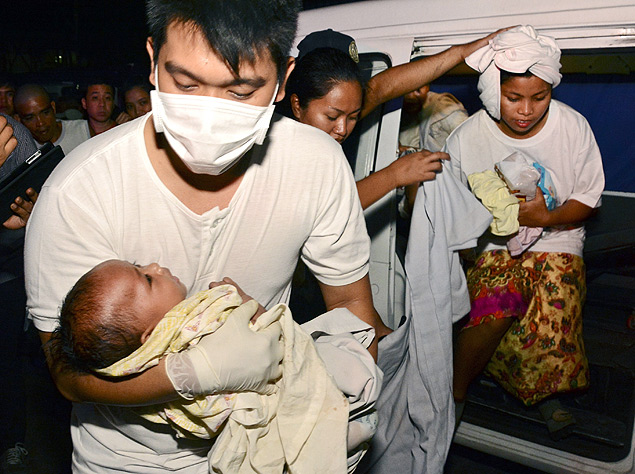 Mdico carrega beb resgatado de naufrgio de balsa nas Filipinas 