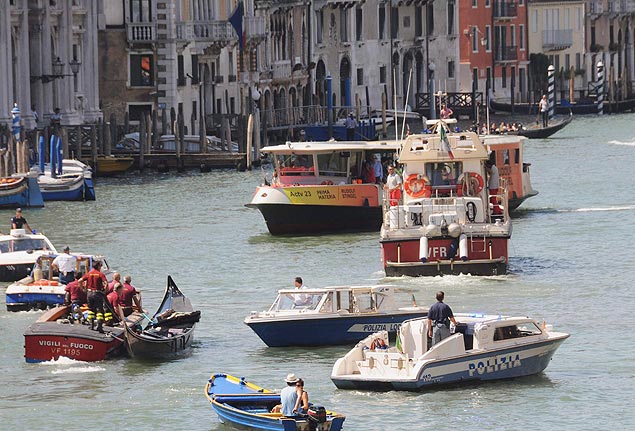 Bombeiros e policiais inspecionam gndola e barca de passageiros aps acidente em Veneza; turista alemo morreu