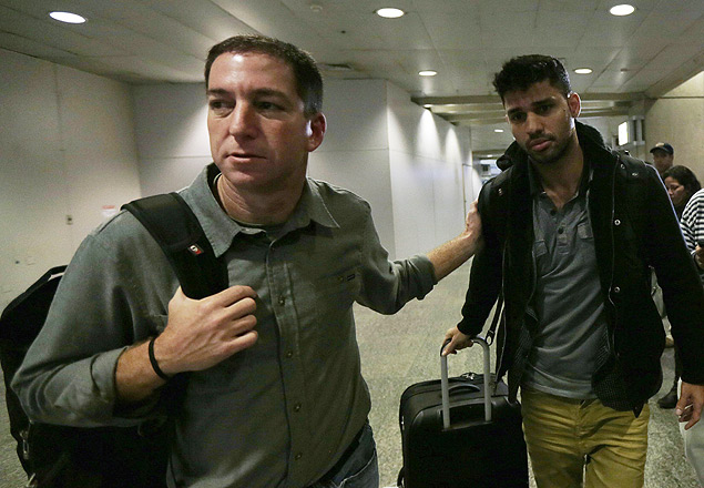 O jornalista americano Glenn Greenwald (à esq.) e o namorado dele, David Miranda, no aeroporto do Rio, no domingo passado