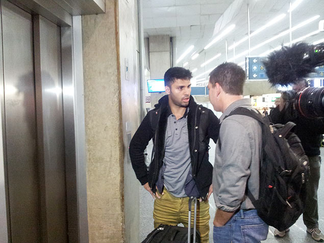 O brasileiro David Miranda chega ao aeroporto no Rio e é cercado por jornalistas