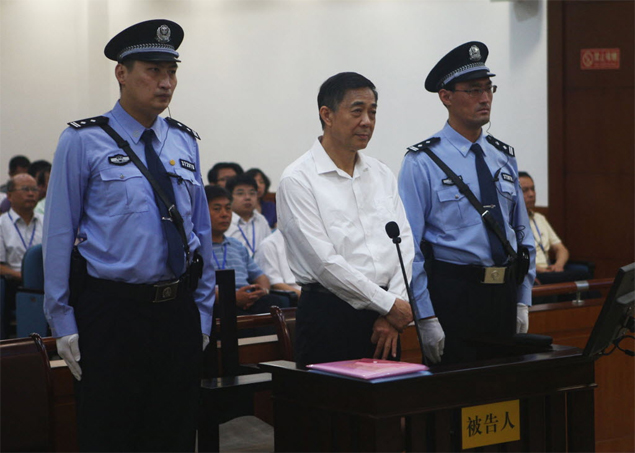 Ex-dirigente do Partido Comunista chins Bo Xilai faz gesto misterioso com os dedos ao comparecer a julgamento em tribunal