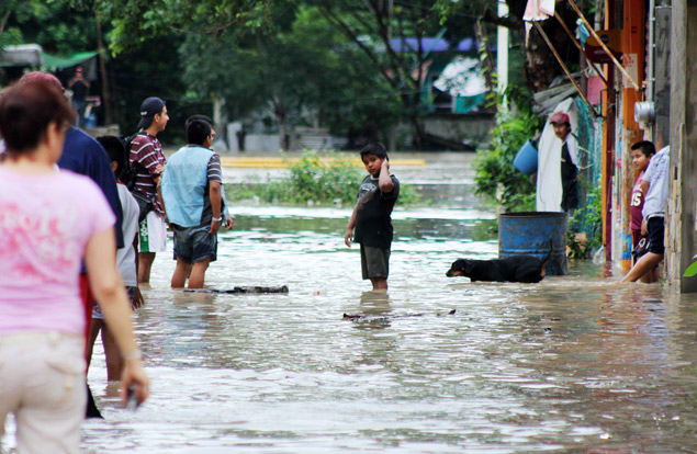 Moradores andam por rua inundada em Poza Rica, no estado de Veracruz, no Mxico