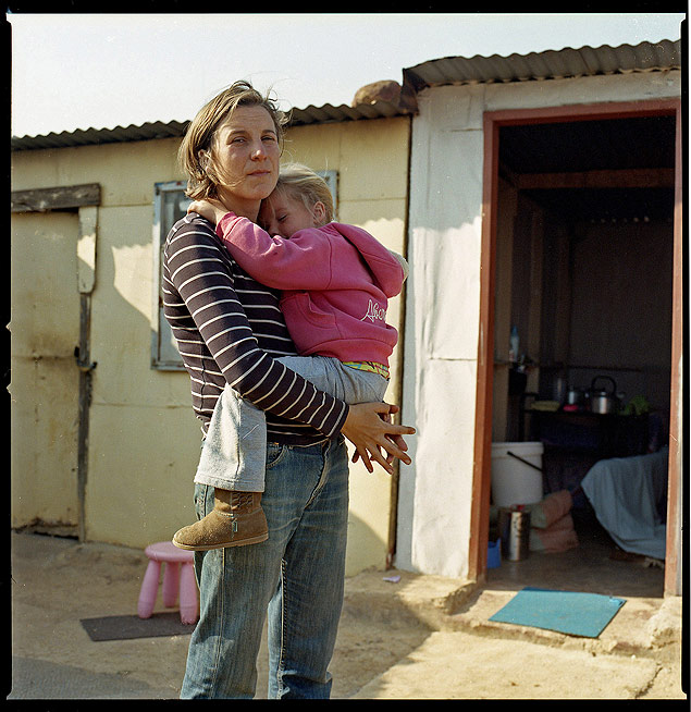 Ena Hewitt com a filha Julia, 4, perto do barraco na favela sul-africana de Phomolong, onde elas passaram um ms