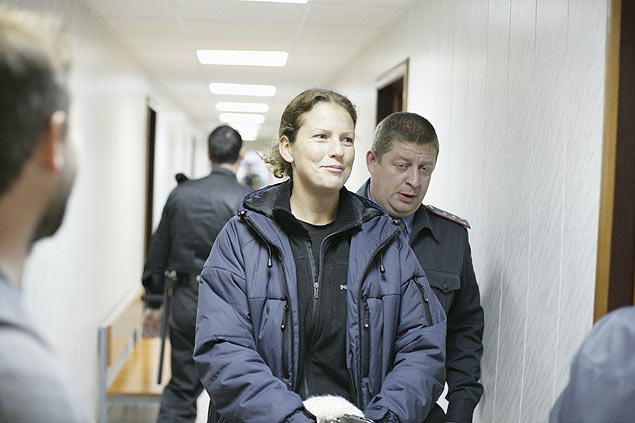 A brasileira Ana Paula Alminhana Maciel é escoltada no tribunal de Murmansk, na Rússia, após ter sido detida com a tripulação de um navio do Greenpeace que protestava contra a exploração de petróleo no Ártico