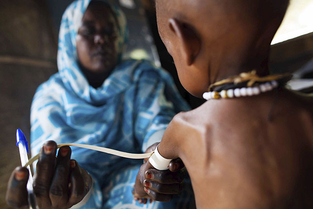 Criana subnutrida  atendida por enfermeira de ONG em campo de deslocados em Darfur, no Sudo 