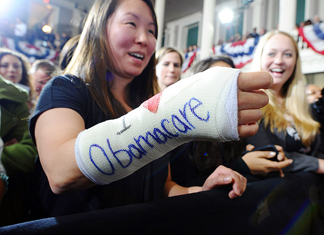 (FILES) Cathey Park shows her arm in a cast on which "I love Obamacare" is written as she waits to hear US President Barack Obama speak on healtcare at the Faneuil Hall in Boston, Massachusetts, in this October 30, 2013, file photo. Only 100,000 people have enrolled in the new US Obamacare health plan so far, and fewer than 27,000 have made it through a faulty federal sign-up website, the government said November, 13, 2013. The figure of 106,185 registrations represents only 1.5 percent of the estimated total sign up for the plan by the end of the enrollment period in March, the Health and Human Services Department said. AFP Photo/Jewel Samad/FILES ORG XMIT: J675