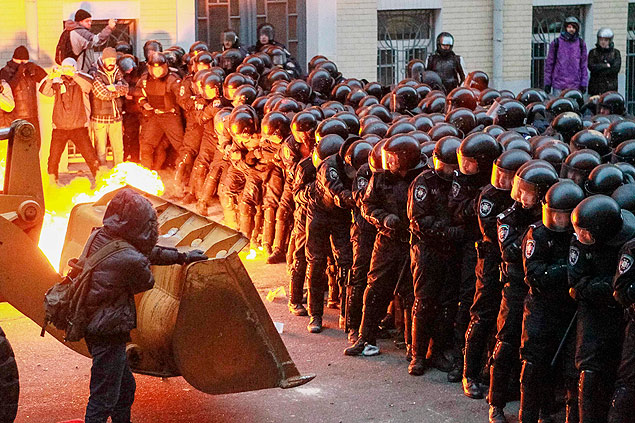 Manifestantes usam escavadeira para tentar furar o bloqueio policial prximo  sede do governo da Ucrnia