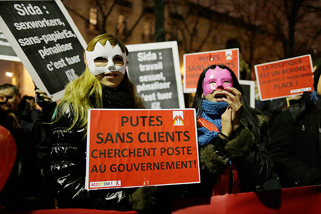 Ativista contra multa com cartaz que diz: 'prostitutas sem cliente buscam emprego no governo