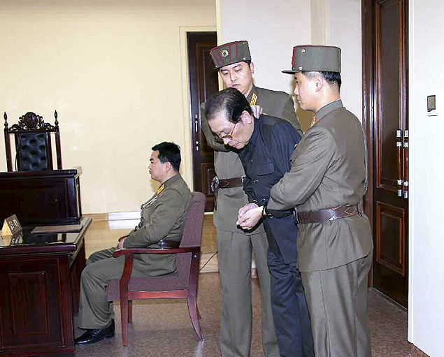 Jang Song-thaek, com as mos atadas,  retirado do tribunal pelas foras de segurana; tio de ditador  executado