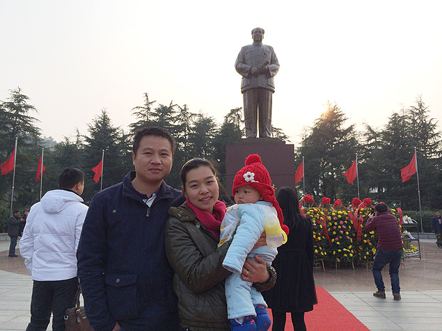 O gerente de fbrica Mao Jiarui com sua mulher, a enfermeira Tao Pingping, e o filho de dez meses diante da esttua de Mao