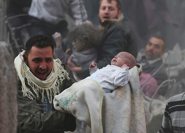 Homem segura beb que sobreviveu a um ataque areo de foras leais ao presidente Bashar al-Assad em Damasco