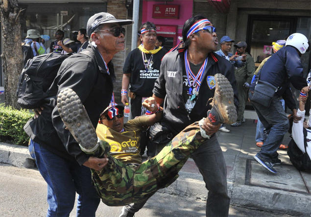 Manifestantes ajudam colega ferido aps exploso de granada durante protesto antigoverno em Bancoc