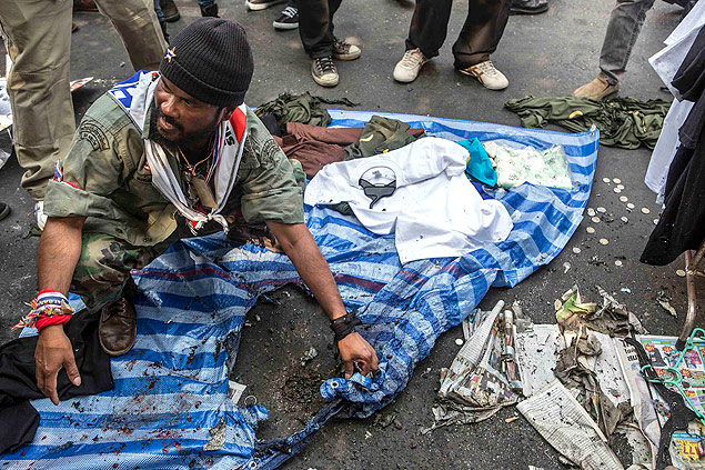 Manifestante antigoverno mostra estrago em banca de produtos que foi danificada aps exploso